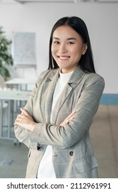 Young Asian Business Woman With Smile In Office Portrait. Japanese Professional Female Worker In Suit With Happy Face. Successful Manager Employee Or Boss Assistant. Satisfied Corporate Staff