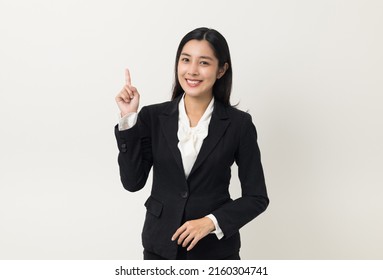 Young Asian Business Woman Smiling To Camera Standing Pose On Isolated White Background. Female Around 25 In Suit Portrait Shot In Studio.