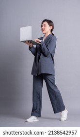 Young Asian Business Woman Standing On Gray Background