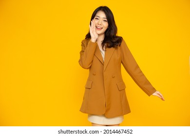 Young Asian Business Woman In Suit Speech And Announce Isolated On Yellow Background