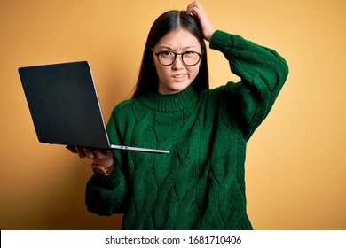 Young Asian Business Woman Wearing Glasses And Working Using Computer Laptop Confuse And Wondering About Question. Uncertain With Doubt, Thinking With Hand On Head. Pensive Concept.