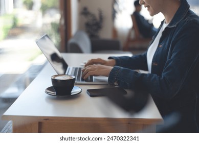 Young asian business woman working on laptop computer at coffee shop. Female freelancer connecting the internet, online working from cafe, remote work, telecommuting, freelance lifestyle - Powered by Shutterstock