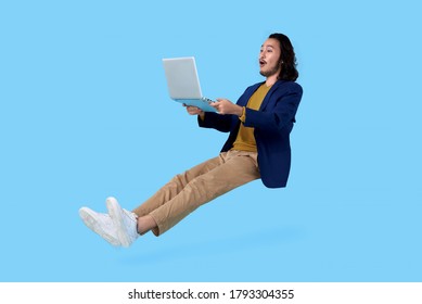 Young asian businessman hand holding computer laptop floating in mid-air isolated on blue background.