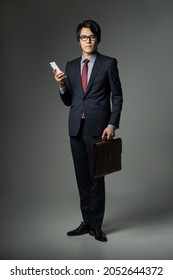 Young Asian Businessman Holding A Smart Phone.