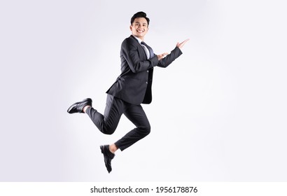 Young Asian businessman jumping on white background