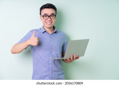 Young Asian businessman posing on green background - Powered by Shutterstock