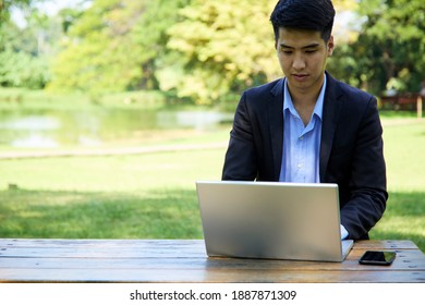 A young Asian businessman sitting in the garden for work