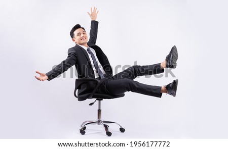 Young Asian businessman sitting on chair on white background