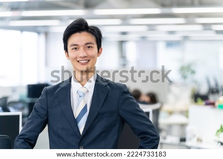Young Asian businessman standing in the office.