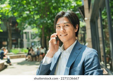 Young Asian businessman working in the business district - Powered by Shutterstock