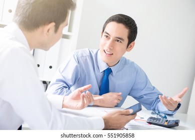 Young Asian Businessmen Consulting At Meeting Table In The Office