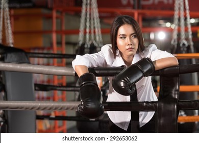 Young Asian businesswoman with boxing glove on boxing ring. Winner and business success concept