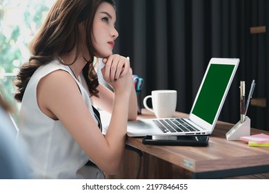 Young Asian Businesswoman Having Conversation Chatting While Using Green Screen Laptop At House. Work At Home, Video Conference, Online Meeting Video Call, Virtual Meeting, Remote Learning, E-learning