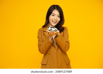 Young Asian businesswoman holding car model isolated on yellow studio background, Car Insurance concept - Powered by Shutterstock