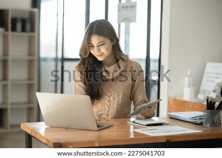 Young Asian businesswoman holding notebook about business, spending money