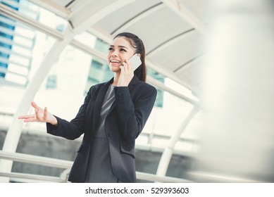 Young Asian Businesswoman Talking On Smartphone With Hand Gesture