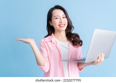 Young Asian businesswoman using latop on background
