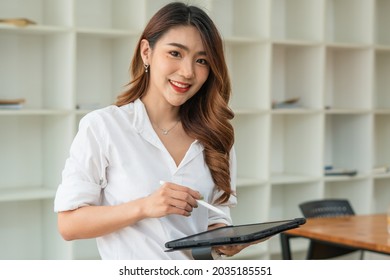 Young Asian Businesswoman Using Tablet With Smiling Face, Positive Emotion, At Office, Casual Office Life Concept