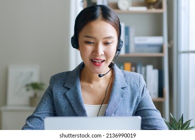 Young Asian Businesswoman Wearing Headphone, Call Center, Customer Service Talking On Video Call Conference Or Virtual Meeting In Office, Front View