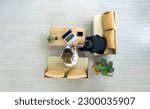 Young asian businesswoman in white suit and senior manager meeting in modern coworking space. Flower pot, coffee cup, laptop and and tablet computer are on wooden table. Top view