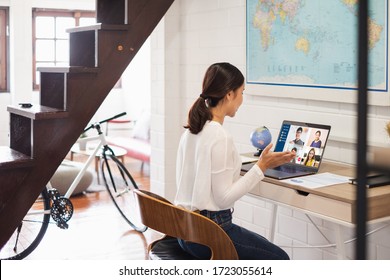 Young Asian businesswoman work at home and virtual video conference meeting with colleagues business people, online working, video call due to social distancing at home office