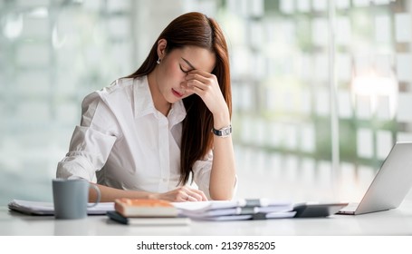 Young Asian Businesswoman Working On Laptop Computer, Stressed Has A Headache And Thinks Hard From Work At The Office.