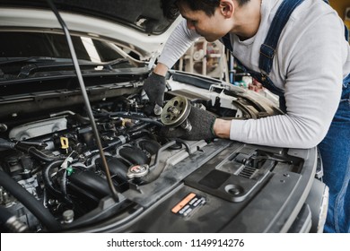 Young Asian Car Mechanic With Spare Parts Working At Service Center Repair