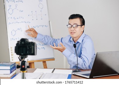 Young Asian Chemistry Teacher Explaining Formulas On Whiteboard When Hosting Online Class For School Students