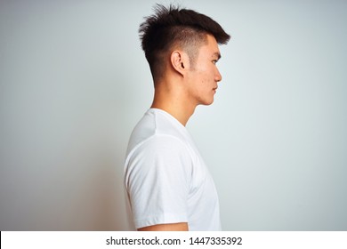 Young Asian Chinese Man Wearing T-shirt Standing Over Isolated White Background Looking To Side, Relax Profile Pose With Natural Face And Confident Smile.