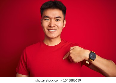 Young asian chinese man wearing  t-shirt standing over isolated red background with surprise face pointing finger to himself