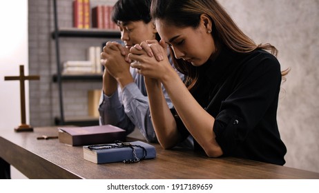 A Young Asian Christian Couple Praying To Jesus Christ In A Church.