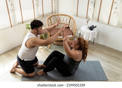 Young Asian Chubby Couple Exercising And Working Out Together In Living Room At Home. Plus Size Man And Woman Cheering Up And Show Positive Energy And Encourage Each Other That They Can Do It