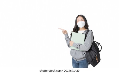 Young Asian College Student Wears Face Mask And Hoodie Sweatshirt With Laptop And Backpack Isolated Over White Background