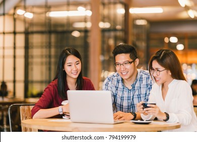 Young Asian college students group or coworkers using laptop computer together at cafe or university. Casual business, freelance work, coffee break meeting, e-learning or e-commerce activity concept