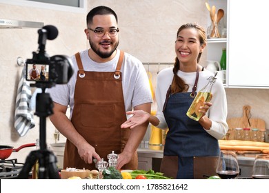 Young Asian Couple Blogger Vlogger And Online Influencer Recording Video Content On Healthy Food In The Kitchen	