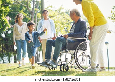 Young Asian Couple And Child Visiting Grandparents In Nursing Home