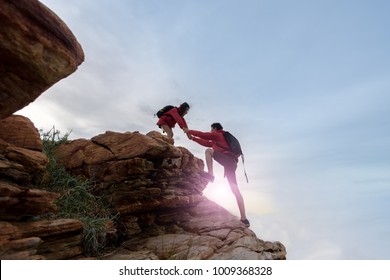 Young Asian Couple Climbing Up On The Mountain,hiking Teamwork ,success ,helps , Business ,Together We Can Concept. 