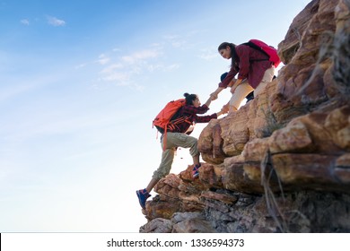 Young Asian Couple Climbing Up On The Mountain,hiking And Team Work Concept.