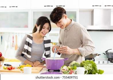 Young Asian Couple Cooking In Kitchen