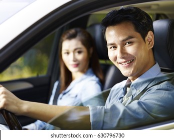 Young Asian Couple Enjoying Ride In A Car.