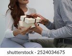 A young Asian couple expresses their love by surprising each other with gifts. Feel the sweet smiles and love of a newly married Asian couple.