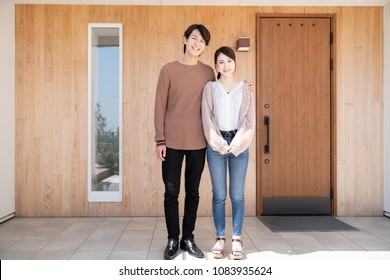 Young Asian Couple In Front Of The House.