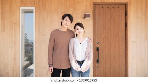 Young Asian Couple In Front Of The House.