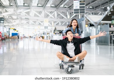 Young Asian Couple Are Happily Waiting On A Luggage Trolley While Waiting For A Flight At Airport Terminal,opening International Travel Flights After The Coronavirus 2019 (COVID-19) Outbreak Ends.