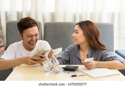 Young asian couple happy with money at home
