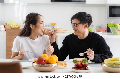 Young Asian Couple Happy To Sit And Eat At The Dining Table In The Kitchen At Home Enjoying A Delicious Meal. Happy Married Couple Talking And Laughing Concept Happy Family Relationship Lifestyle