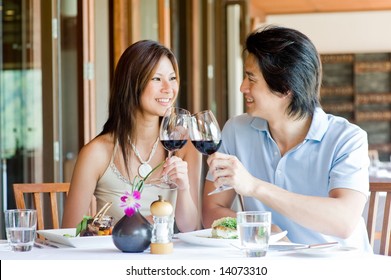 A Young Asian Couple Having Dinner At A Restaurant