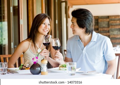 A Young Asian Couple Having Dinner At A Restaurant