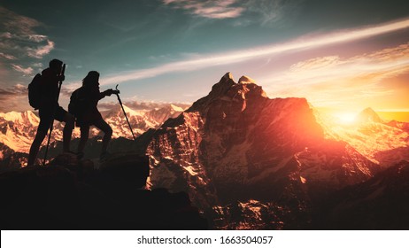 Young Asian Couple Hikers Climbing Up On The Peak Of Himalaya Mountains. People Helping Each Other Hike Up A Mountain At Sunrise. Giving A Helping Hand. Climbing ,Helps And Team Work Concept