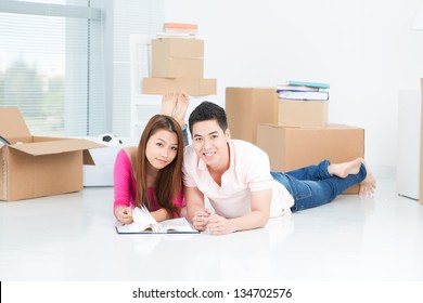 Young Asian Couple Lying On The Floor With Photo Album